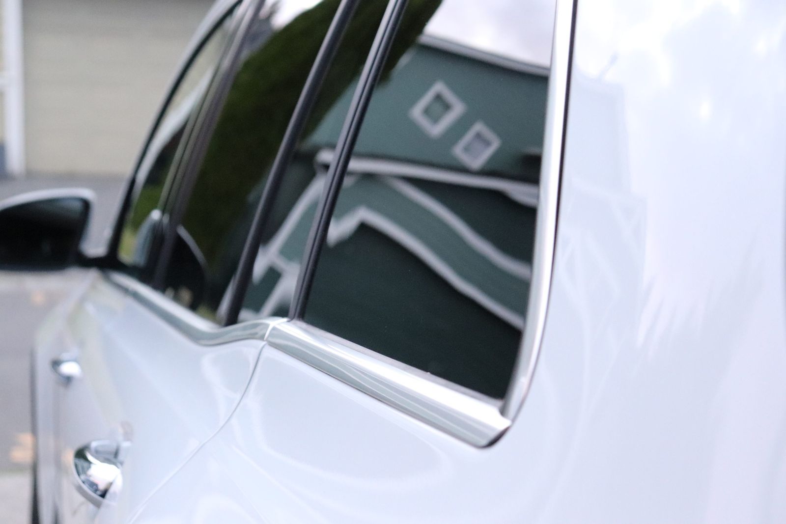 Polished chrome window trim and beltline on a white Mercedes