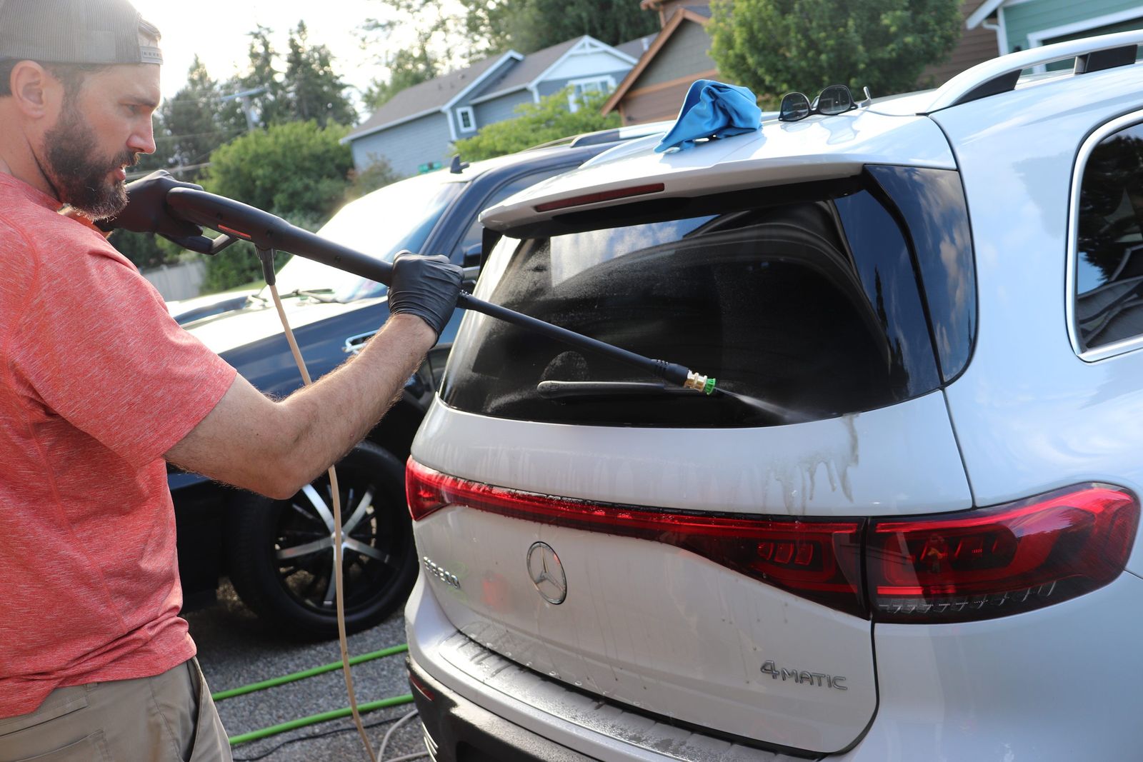 Rinsing the rear glass and hatch of a white SUV