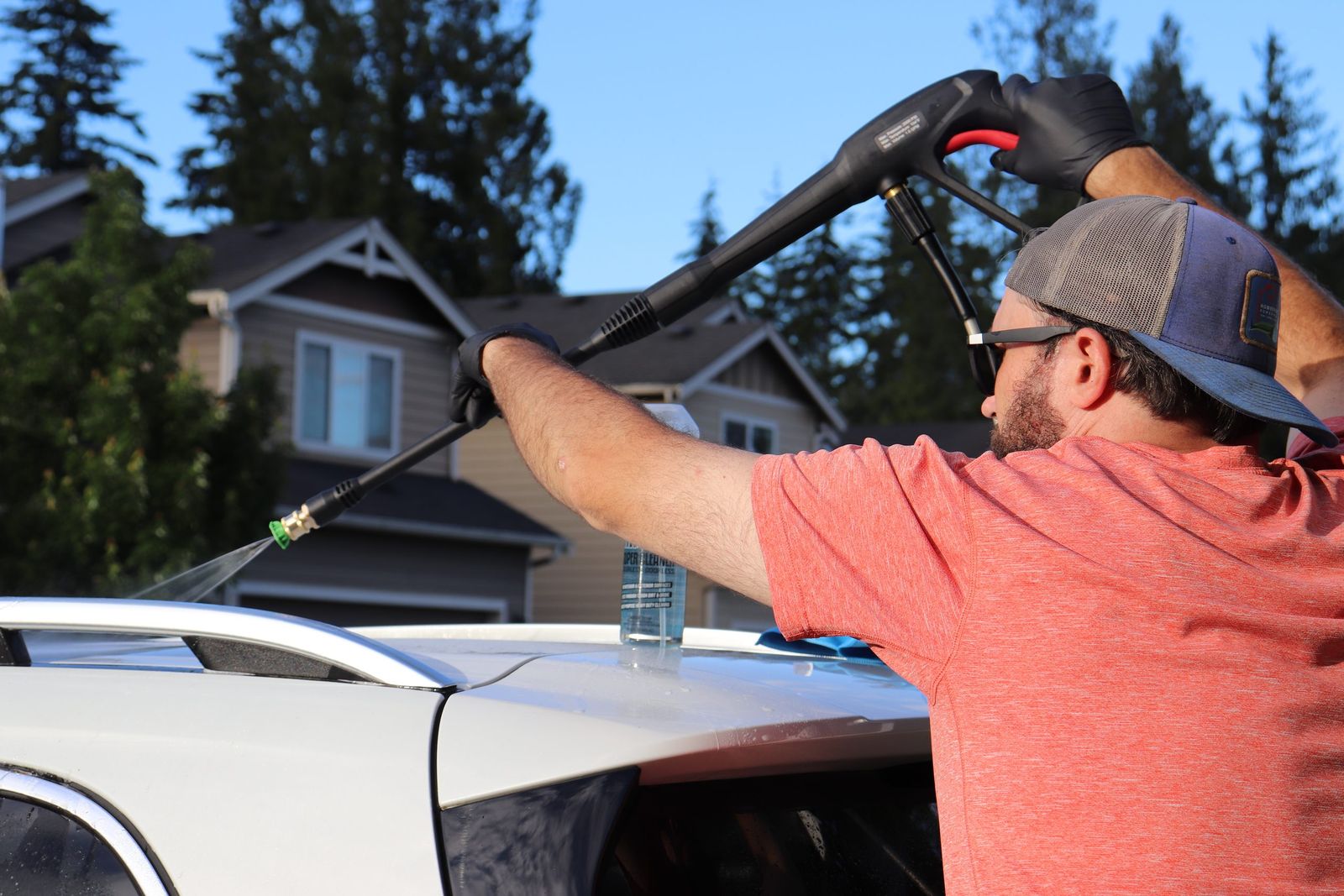 Spraying cleaner along the roofline during an exterior detail