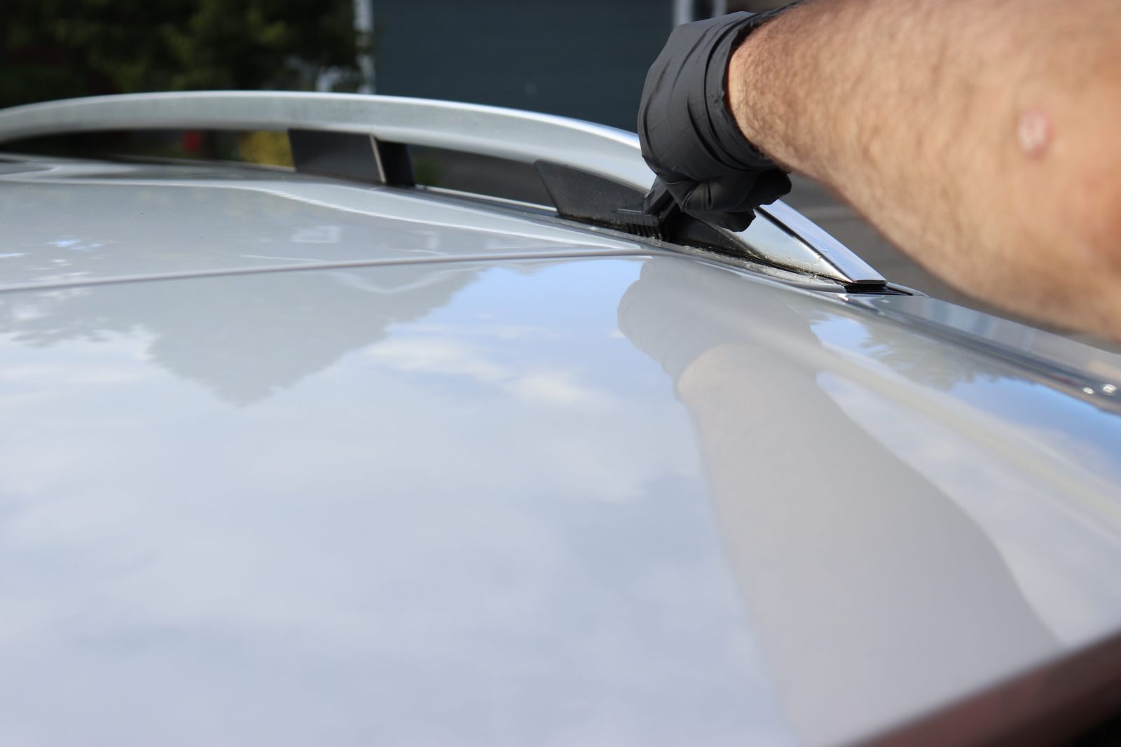 Detailing the roof rail and door seal of a white SUV